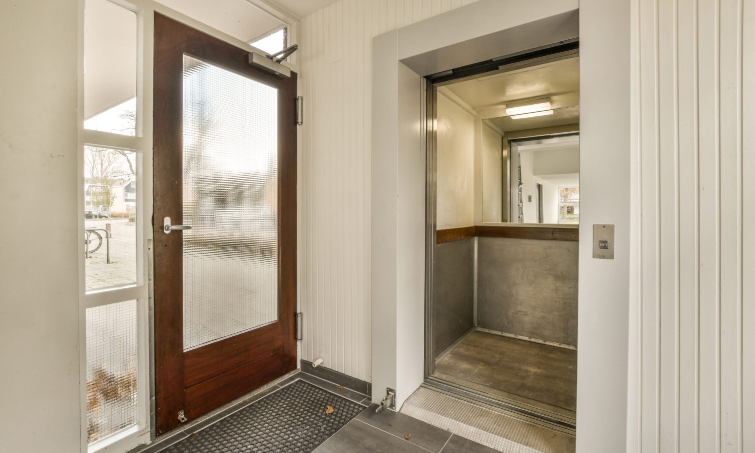 the inside of a house with an open door and no one person standing on the floor in front of it